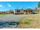 Quaint home featuring a covered porch, gravel driveway, and well-kept landscaping with storage building on property at 210 Holloway Rd, Roxboro, NC 27573