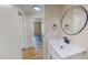 Hallway view leading to bathroom with a large round mirror at 210 Holloway Rd, Roxboro, NC 27573