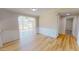Open living room space with wainscoting and light wood flooring and open access to a room with large windows at 210 Holloway Rd, Roxboro, NC 27573