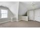 A carpeted attic space with neutral walls, a window, and multiple doorways, offering ample storage or conversion potential at 213 Billingrath Turn Ln, Cary, NC 27519