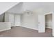A carpeted attic area with multiple doors and a ceiling fan, offering versatility and functionality at 213 Billingrath Turn Ln, Cary, NC 27519
