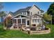 Landscaped backyard featuring a stone patio, grill, and screened-in porch for outdoor entertaining at 213 Billingrath Turn Ln, Cary, NC 27519