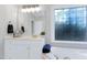 Well-lit bathroom featuring a vanity with a mirror and tub with a designer window at 213 Billingrath Turn Ln, Cary, NC 27519