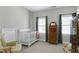 Cozy Bedroom featuring a crib, rocking chair, dresser, and windows with curtains at 213 Billingrath Turn Ln, Cary, NC 27519
