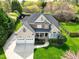 Beautiful two-story home featuring a stone facade, a covered porch, a well-manicured lawn, and a three-car garage at 213 Billingrath Turn Ln, Cary, NC 27519