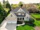 Beautiful two-story home featuring a stone facade, a covered porch, a well-manicured lawn, and a three-car garage at 213 Billingrath Turn Ln, Cary, NC 27519