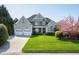 Charming two-story home with a well-manicured lawn, two-car garage, and inviting front porch at 213 Billingrath Turn Ln, Cary, NC 27519