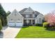 Beautiful home boasting a manicured front lawn, two-car garage, and a stone-accented facade at 213 Billingrath Turn Ln, Cary, NC 27519
