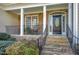 Inviting front porch with stone accents, rocking chairs, and a beautifully crafted front door at 213 Billingrath Turn Ln, Cary, NC 27519