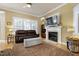 A living room features a leather couch, fire place, carpet and windows with lots of light at 213 Billingrath Turn Ln, Cary, NC 27519