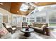 Beautiful sunroom featuring skylights, walls of windows, wood ceiling, and cozy wicker furniture at 213 Billingrath Turn Ln, Cary, NC 27519