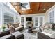 Comfortable sunroom featuring wood ceiling, skylights, walls of windows, and wicker furniture at 213 Billingrath Turn Ln, Cary, NC 27519