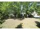 Lush green backyard featuring mature trees, a grassy lawn and a view of the home's exterior at 2133 Persimmon Ridge Dr, Raleigh, NC 27604
