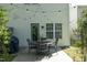 Back patio with string lights, chairs, a metal table, an adjacent window, and a green trimmed door at 2133 Persimmon Ridge Dr, Raleigh, NC 27604