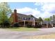 Large brick house with a covered patio and lush landscaping creating a relaxing outdoor space at 2133 Persimmon Ridge Dr, Raleigh, NC 27604