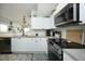 Well-lit kitchen featuring white cabinets, stainless steel appliances, and modern fixtures at 2133 Persimmon Ridge Dr, Raleigh, NC 27604