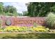 Community sign with a lion logo, colorful flowers, and neatly maintained grass at 2133 Persimmon Ridge Dr, Raleigh, NC 27604