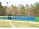 Outdoor tennis court with blue surface and green border enclosed by a black chain-link fence at 2133 Persimmon Ridge Dr, Raleigh, NC 27604