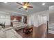 Open-concept living room with hardwood floors, a ceiling fan, and seamless access to the kitchen and dining areas at 219 Begen St, Morrisville, NC 27560