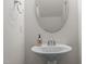 Cozy powder room featuring a pedestal sink, oval mirror, and stylish faucet at 219 Begen St, Morrisville, NC 27560