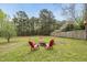Spacious backyard with a fire pit surrounded by Adirondack chairs, perfect for outdoor relaxation at 221 Walkers Way, Willow Springs, NC 27592