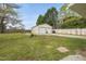 Detached garage in a backyard featuring a lush lawn, bordered by a wooden fence at 221 Walkers Way, Willow Springs, NC 27592
