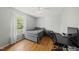 Light-filled bedroom with hardwood floors, neutral walls, and a large window overlooking the yard at 221 Walkers Way, Willow Springs, NC 27592