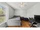 Bright bedroom featuring hardwood floors, a ceiling fan, and a well-lit workspace at 221 Walkers Way, Willow Springs, NC 27592