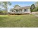 Inviting home with a covered porch, complemented by lush green lawn and mature landscaping at 221 Walkers Way, Willow Springs, NC 27592