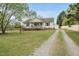 Traditional home boasting a gravel driveway, detached garage, well-maintained lawn and inviting curb appeal at 221 Walkers Way, Willow Springs, NC 27592