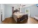 Spacious main bedroom featuring a four-poster bed, hardwood floors, and a large window at 221 Walkers Way, Willow Springs, NC 27592
