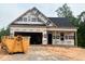 New construction shows a modern home with an attached garage and covered porch being built on a wooded lot at 23 Fetterbush Way, Clayton, NC 27520