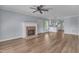 Inviting living room featuring a brick fireplace, ceiling fan and luxury vinyl flooring at 2306 Stafford Ave # A, Raleigh, NC 27607