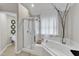 Bathroom featuring a walk-in shower and a soaking tub with a beautiful garden view at 2340 Florida Ct, Raleigh, NC 27615