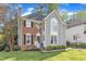 Charming two-story home showcasing architectural details, including a brick facade and arched window on a well-manicured lawn at 2340 Florida Ct, Raleigh, NC 27615