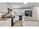 Kitchen with white cabinets, granite countertops, stainless steel appliances and a light brown checker board rug at 2340 Florida Ct, Raleigh, NC 27615