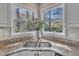 Well-lit kitchen corner featuring a stainless steel sink, granite countertops, and white cabinetry at 2340 Florida Ct, Raleigh, NC 27615