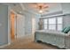 Carpeted bedroom featuring a ceiling fan, tray ceiling and neutral wall color at 236 Summer Place Ct, Clayton, NC 27527