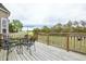 View of a wooden deck complete with a metal table and chairs, surrounded by a lush lawn and foliage at 236 Summer Place Ct, Clayton, NC 27527