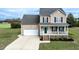 Charming two-story home featuring a cozy front porch, attached garage, and well-manicured lawn at 236 Summer Place Ct, Clayton, NC 27527