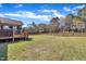 A spacious backyard with a wooden fence, a screened-in back deck, and lush green grass at 24 High Standard Ln, Angier, NC 27501