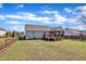 A large, fenced backyard featuring a wood deck, lawn, and vinyl siding on the house at 24 High Standard Ln, Angier, NC 27501