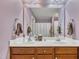 Double vanity bath with cherry cabinetry and a large mirror at 24 High Standard Ln, Angier, NC 27501
