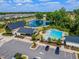 Beautiful community aerial shot of the pool, parking, clubhouse, pond, and surrounding residential area at 242 Luftee Ln, Holly Springs, NC 27540
