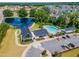 Community aerial shot with a beautiful pond, pool, clubhouse, parking, and surrounding residential area at 242 Luftee Ln, Holly Springs, NC 27540