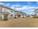 Spacious backyard view of multiple homes with manicured lawns at 242 Luftee Ln, Holly Springs, NC 27540