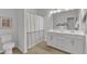 Well-lit bathroom features a double sink vanity and a shower/tub combination with a curtain at 242 Luftee Ln, Holly Springs, NC 27540