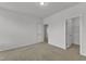 A carpeted bedroom with multiple doorways for easy access at 242 Luftee Ln, Holly Springs, NC 27540