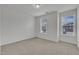 A carpeted room with two windows providing abundant natural light at 242 Luftee Ln, Holly Springs, NC 27540