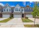 Charming townhome boasts a stone-accented facade, a one-car garage, and well-maintained landscaping at 242 Luftee Ln, Holly Springs, NC 27540
